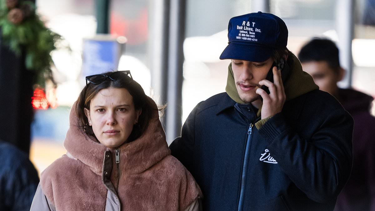 taylor-alert-–-millie-bobby-brown,-19,-wraps-up-in-a-long-brown-coat-as-she-walks-her-pet-pooch-with-fiance-jake-bongiovi,-21,-in-new-york-city